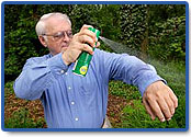 man spraying himself with repellent containing DEET