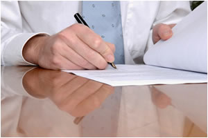 image of a man signing piece of paper