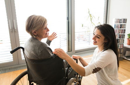 woman speaking to a woman in a wheelchair