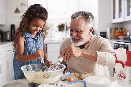 Grandpa cooking with granddaughter