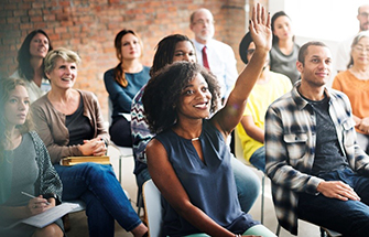 group of people, one with hand raised