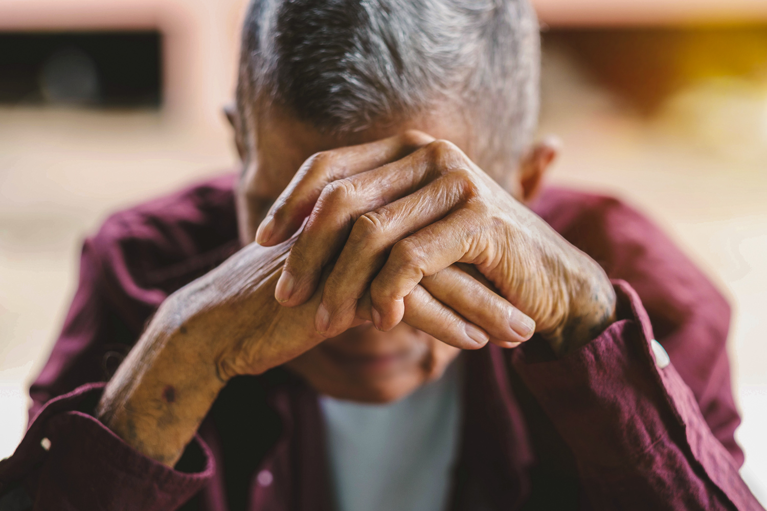 Older man with hands on his face