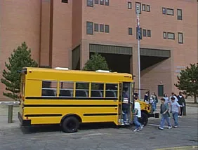 Children leaving school and getting on school bus